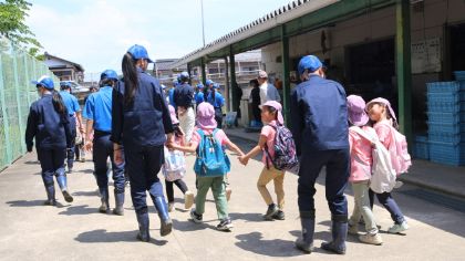 高校生と園児たちが圃場に向かっていく様子